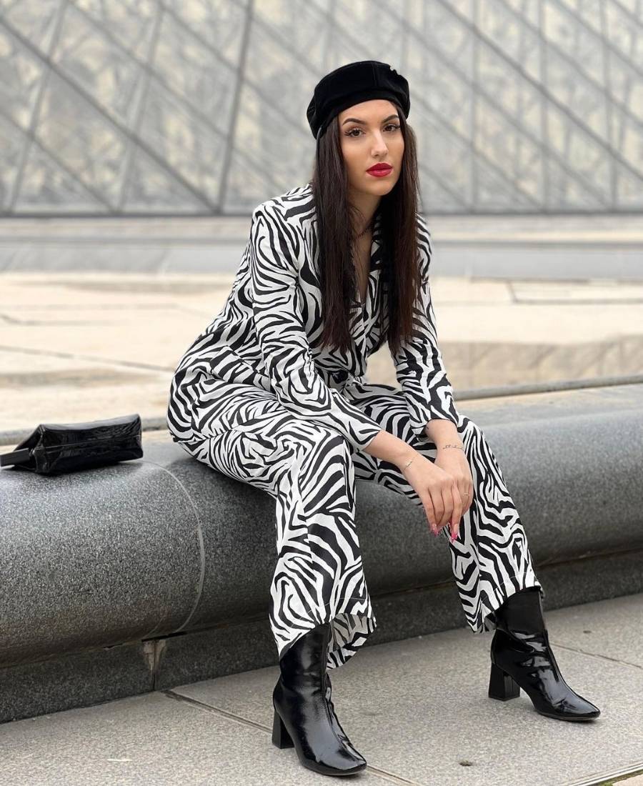 mulher usando terno com estampa de zebra e boina preta
