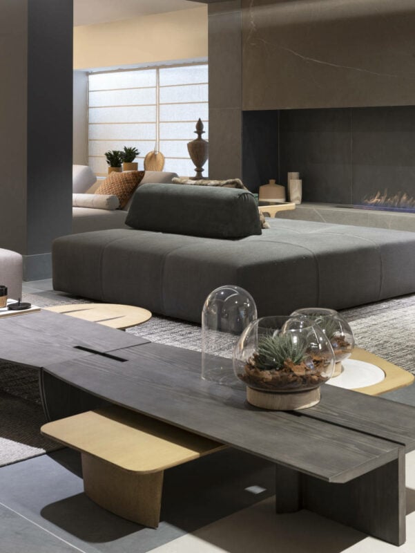 Sala com sofá largo cinza para dois ambientes. 