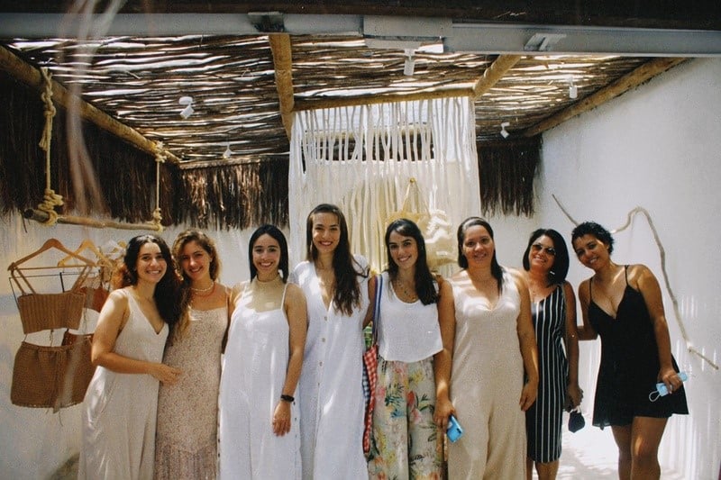 Foto das artesãs do ateliê. 8 mulheres alagoanas abraçadas dentro da loja Artesana.