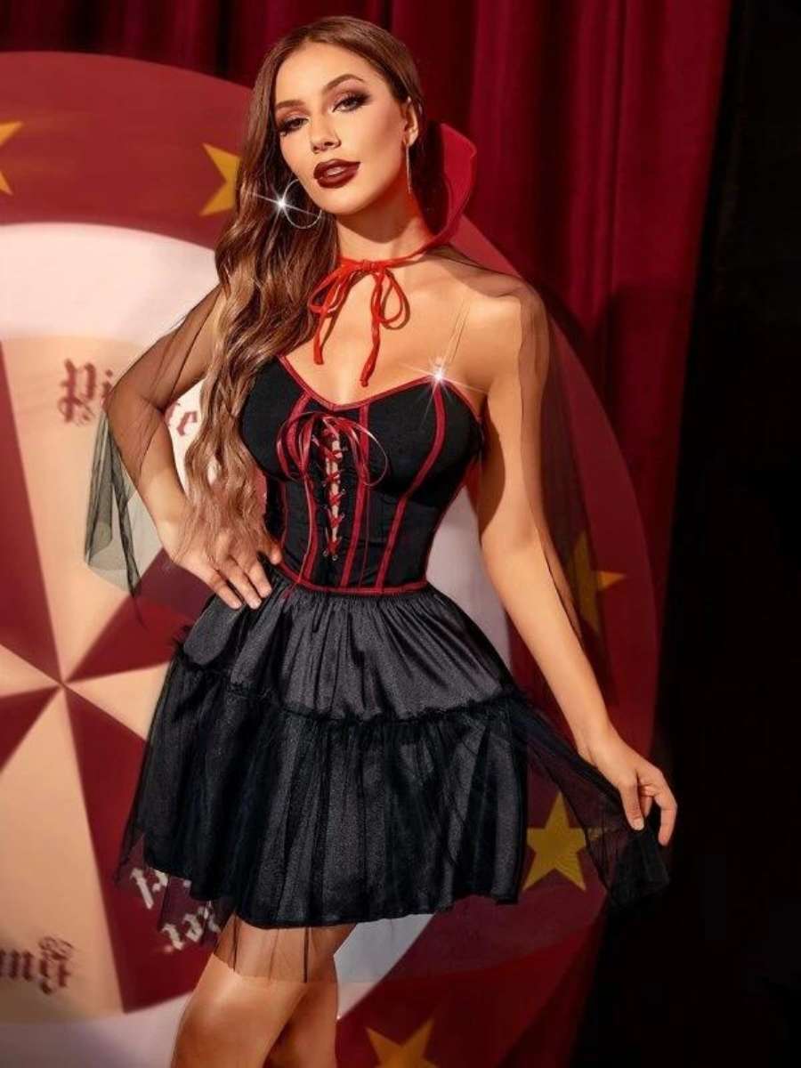 Foto de mulher com fantasia de vampiro para o Halloween: vestido preto acenturado com amarração no cropped e detalhes em vermelho.