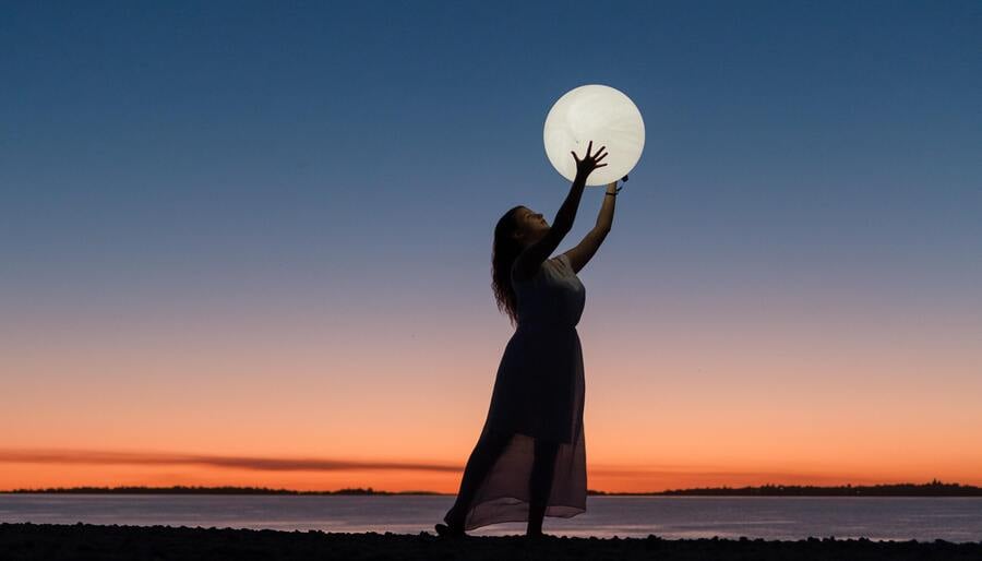 uma mulher segurando o que parece ser a lua cheia