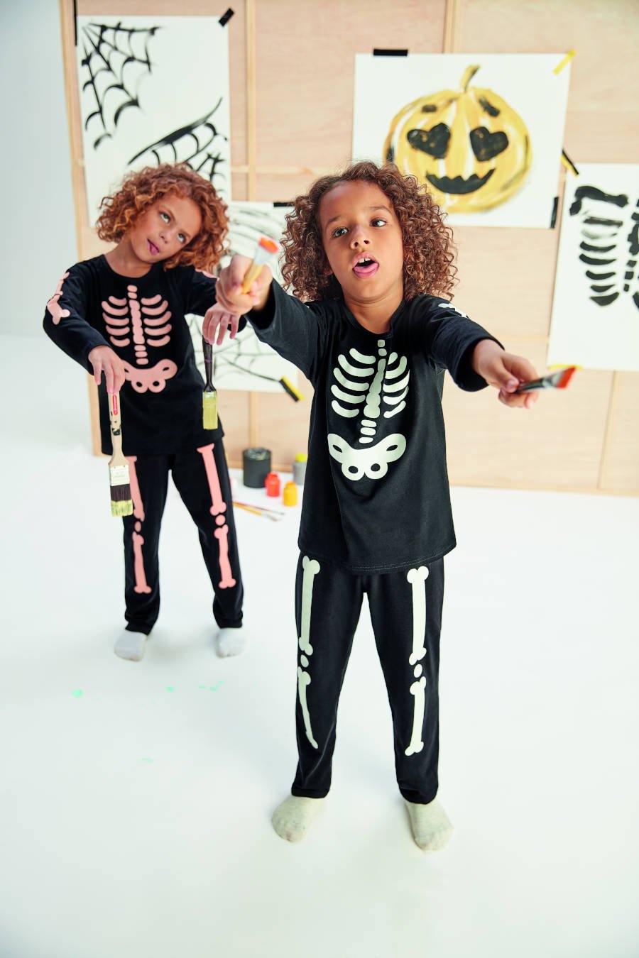 Meninos com pijama de esqueleto.