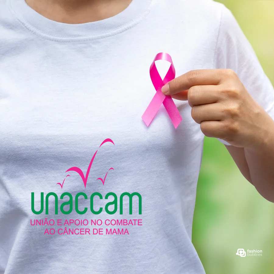 Imagem em fundo verde com mulher de camisa branca segurando no seio direito símbolo da prevenção, diagnóstico e tratamento do câncer de mama: laço rosa. No lado inferior esquerdo, logo da Unaccam: cores predominantes verde e rosa.