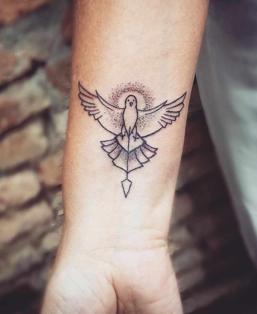 Foto de tattoo do Divino Espírito Santo no braço de uma pessoa.