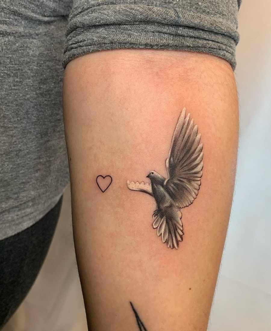 Foto de tattoo do Divino Espírito Santo no braço de uma pessoa.