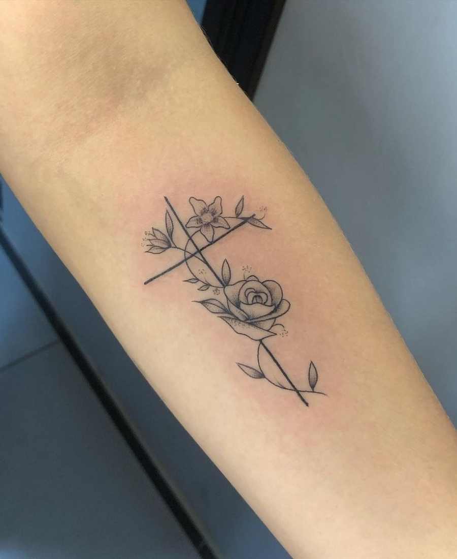 Foto de tatuagem de cruz no braço de uma pessoa.