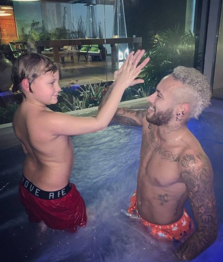 Neymar e seu filho em uma piscina a noite