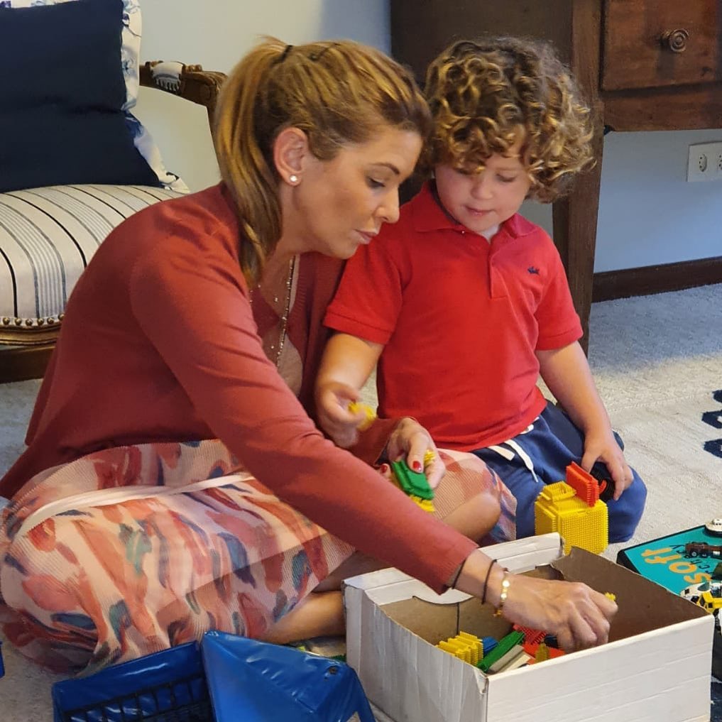Daniela beyruti e um o filho brincando de lego com legos em uma caixa de brinquedos