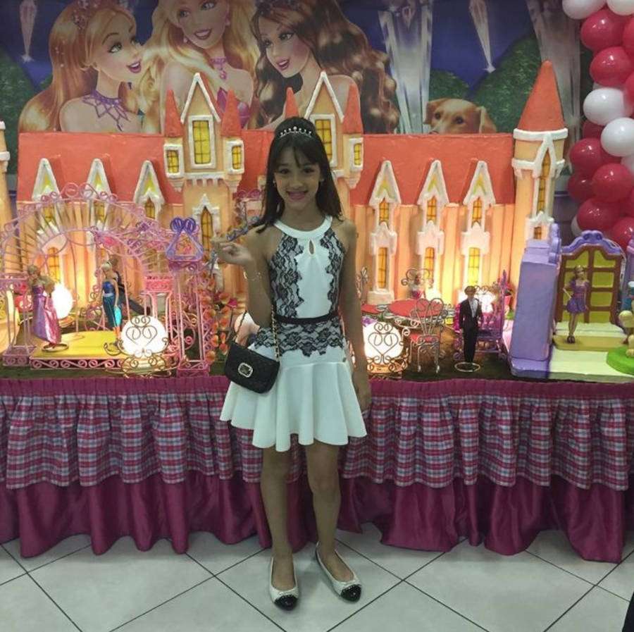 Bia Miranda criança com vestido preto e branco em uma festa de aniversário
