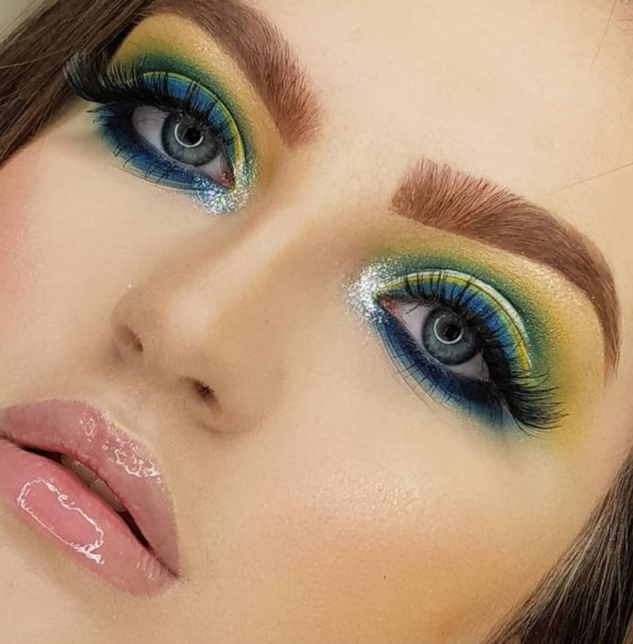 Foto de modelo de maquiagem com olhos maquiados com as cores do Brasil