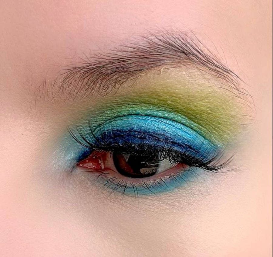 Foto do olho de Denise Pitta com maquiagem para copa verde, amarela e azul