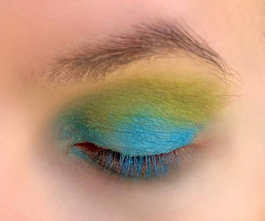 Foto do olho de Denise Pitta com sombra azul acima das sombras verde e amarela