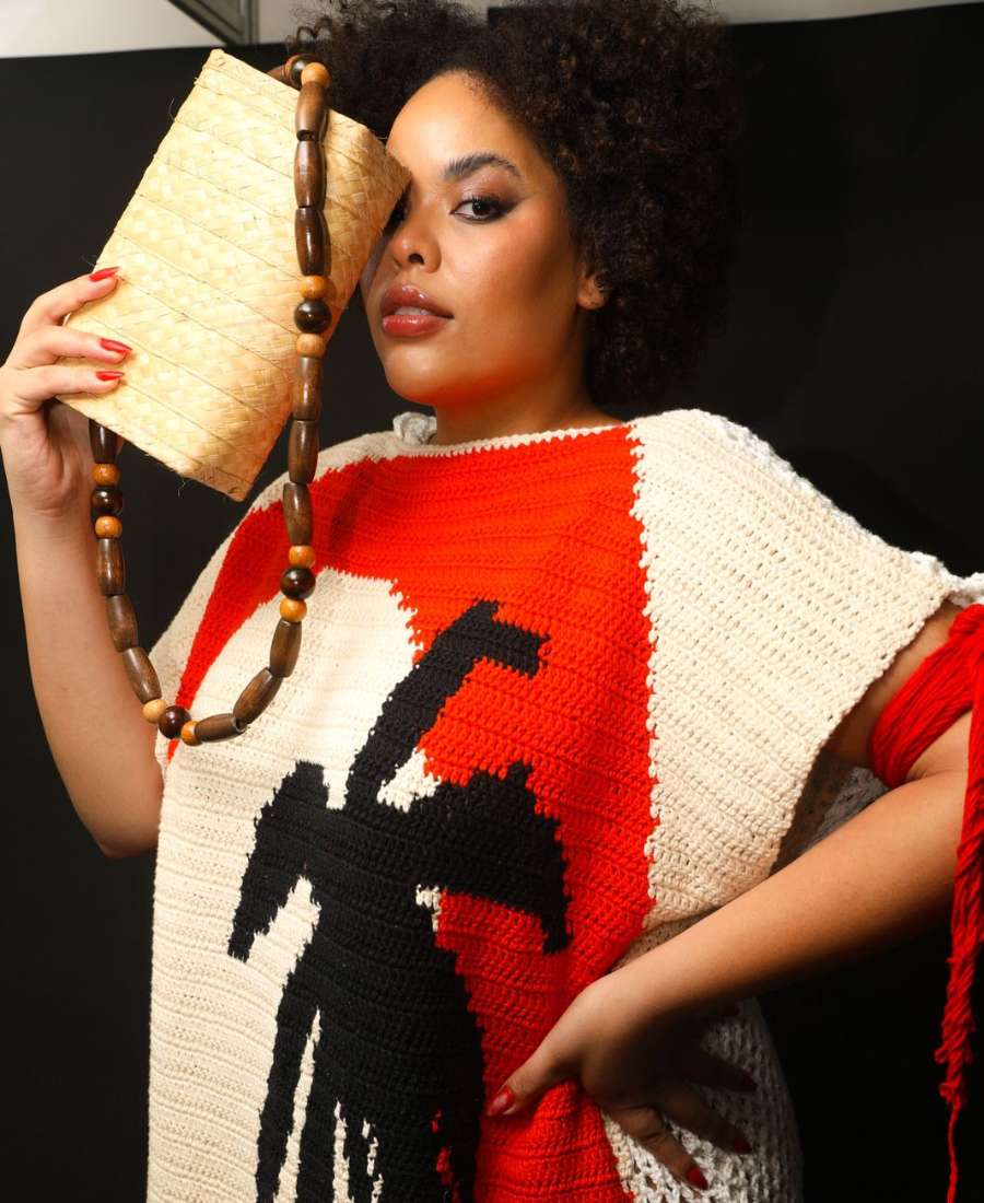 foto de detalhe de modelo negra plus size com vestido em crochê branco, vermelho e preto