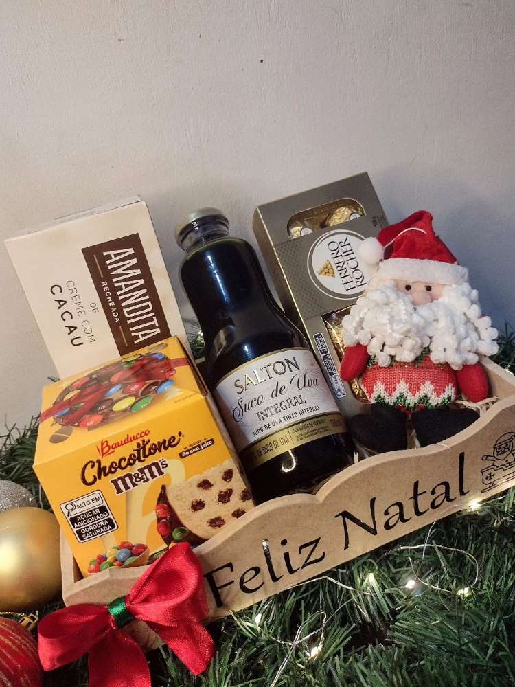 Caixote de madeira escrito feliz natal com doces, bebida e pelúcia do Papai Noel. 