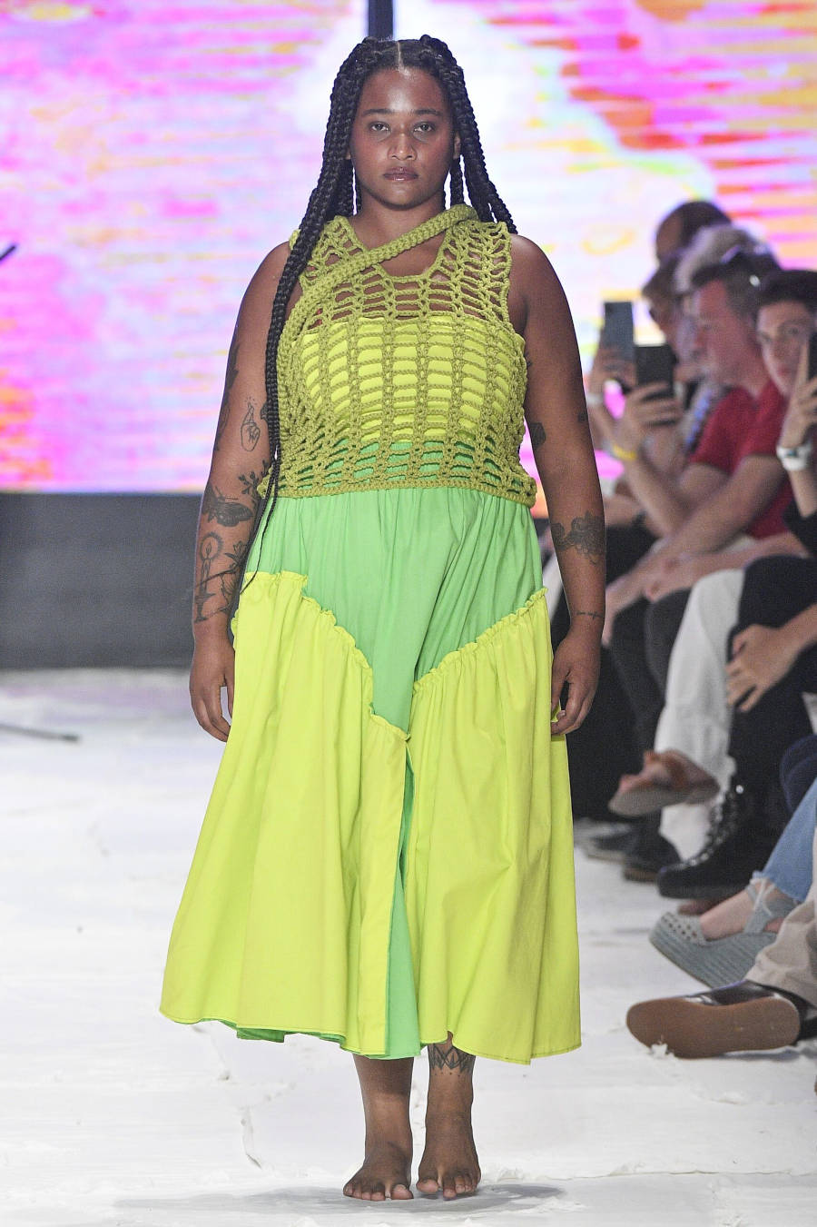 Mulher com vestido verde e amarelo.