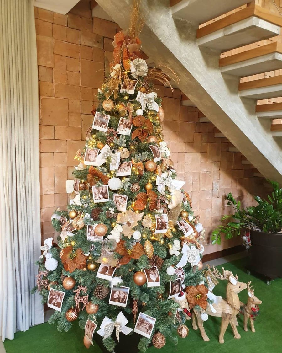 Árvore de Natal com fotos e enfeites tradicionais.