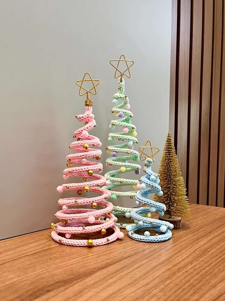 Árvores de Natal pequenas em rosa, verde e azul, circulares e artesanais.