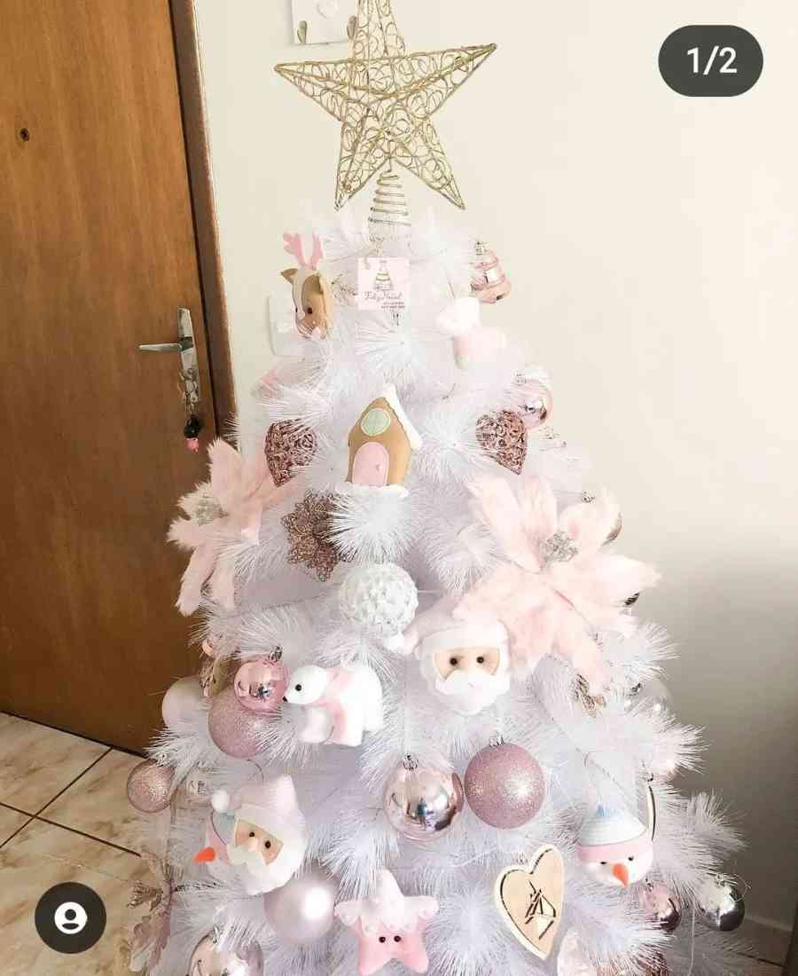 Foto de árvore de natal branca com decoração rosa claro. 