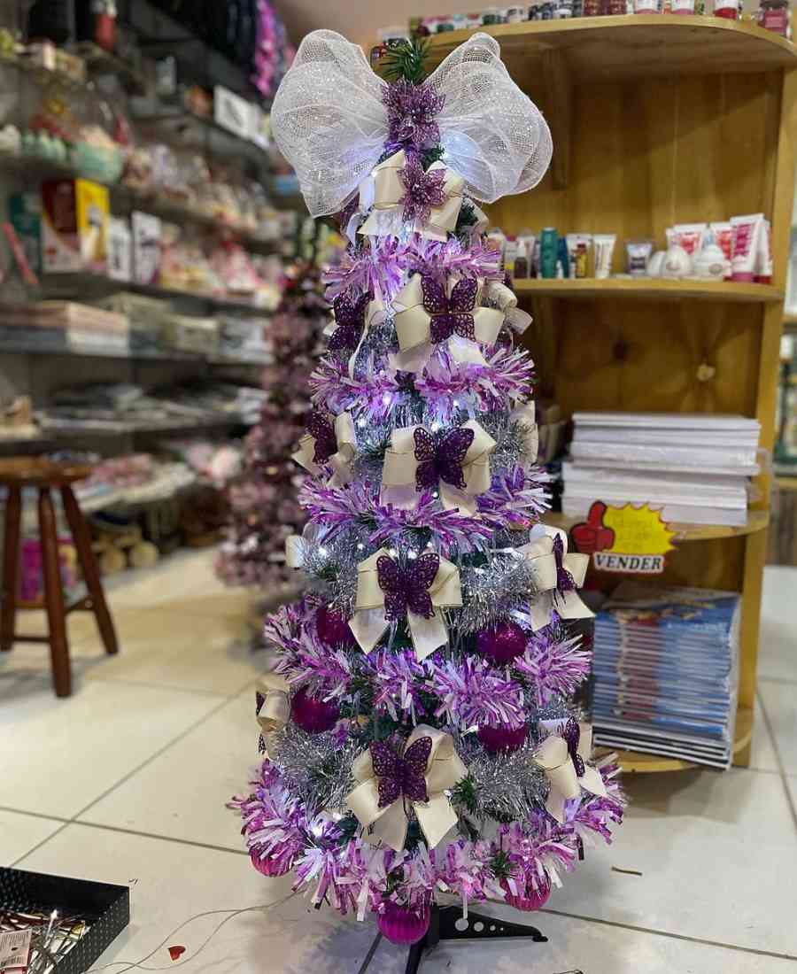 Foto de árvore de natal com decoração lilás.
