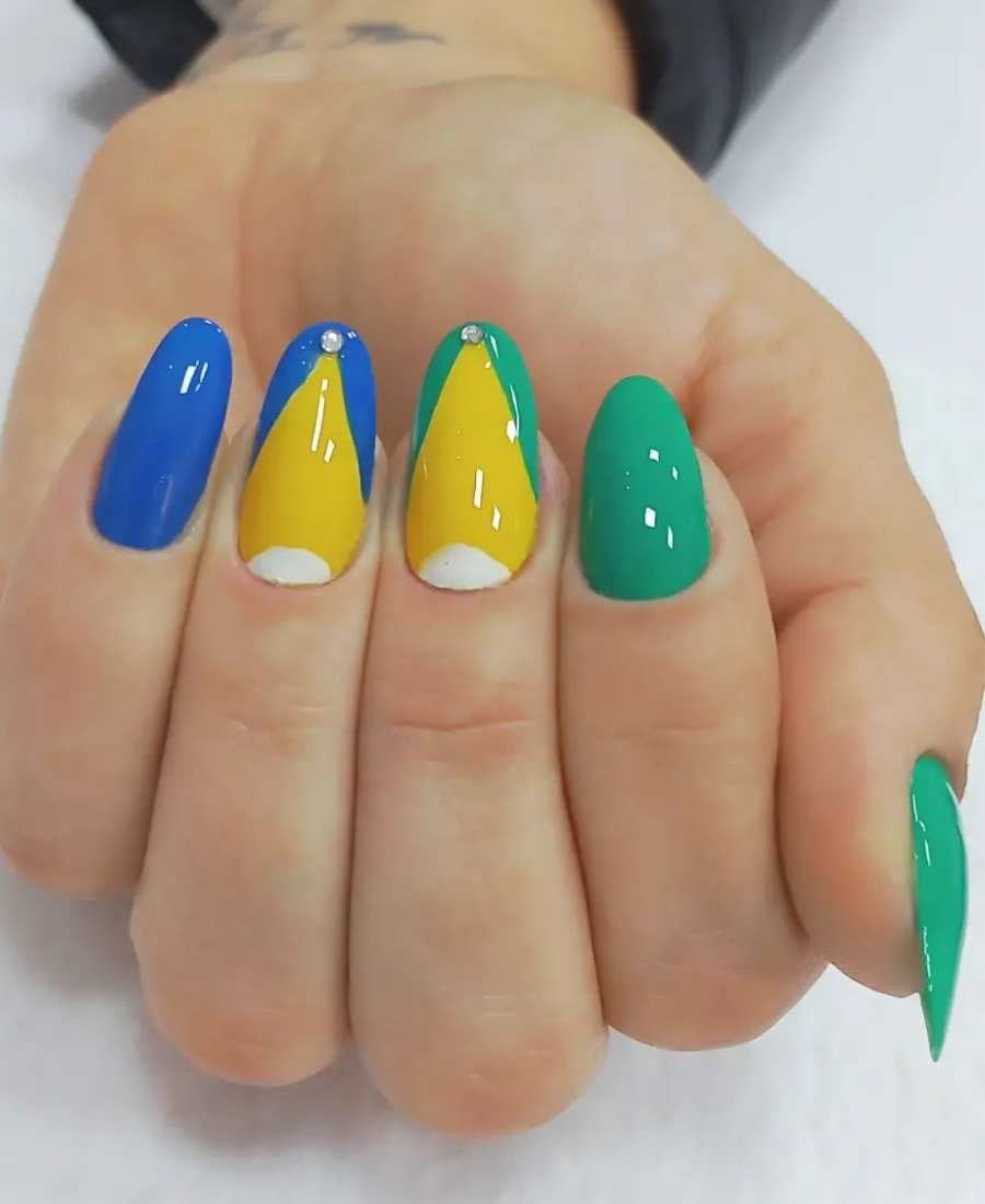 Imagem de mão decoradas com esmalte. Cores usadas: verde, azul, amarelo e branco, além de pedrinhas decorativas.Arte, inspirada na bandeira do Brasil.