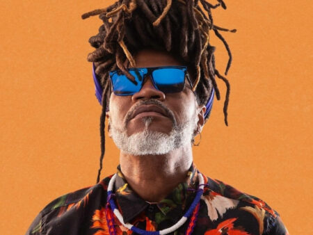 Foto de Carlinhos Brown no fundo laranja, olhando para cima