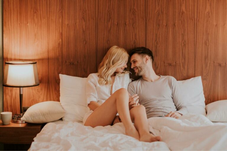 casal apaixonado deitado na cama desfeita se olhando, como apimentar relação