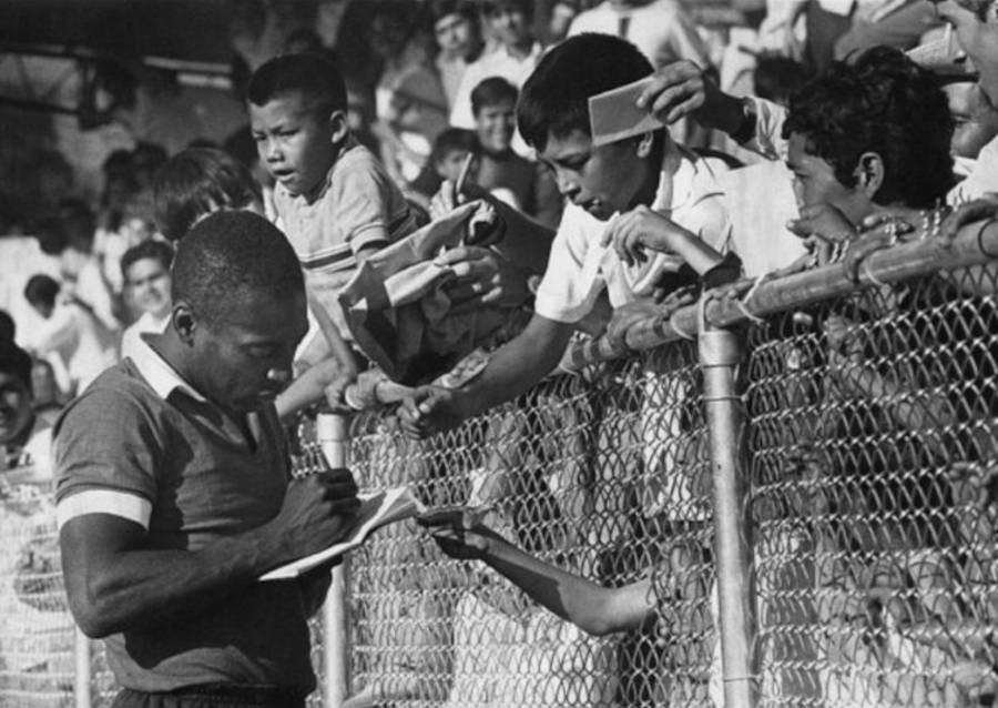 Pelé já mais velho dando autógrafo para fãs