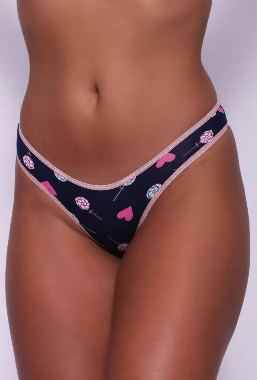 Foto da parte da frente da Calcinha Tanga com o fundo azul escuro e desenhos de corações e pirulitos