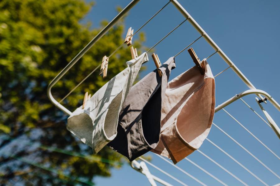 calcinhas de tons neutros penduradas em varal secando ao ar livre, como cuidar de roupas íntimas