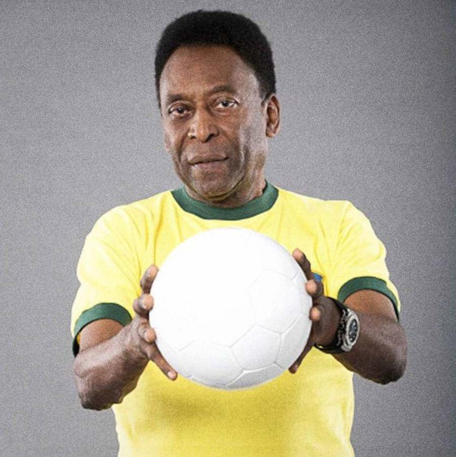 Pelé com a camisa do Brasil segurando uma bola branca