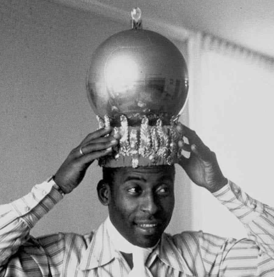 Pelé é considerado o Rei do Futebol: Foto do craque com um troféu na cabeça