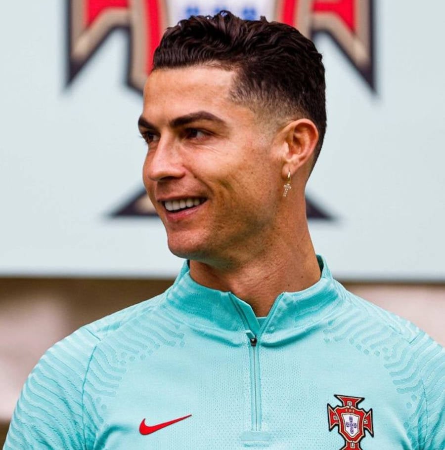 Foto de Cristiano Ronaldo sorrindo olhando para o lado com o casaco da Seleção Portuguesa