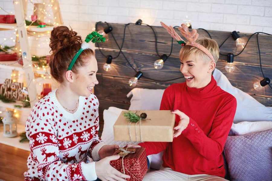 Foto de duas garotas trocando presentes no amigo ladrão de Natal.
