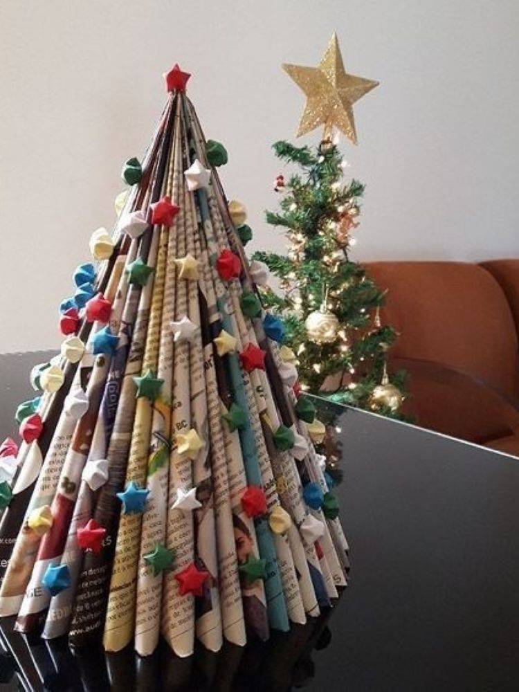 Árvore de Natal feita de jornal e enfeitada com estrelas coloridas.