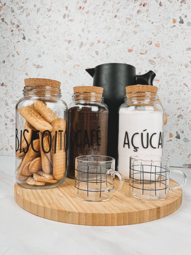 Bandeja de madeira com pote de açúcar e guloseimas, xícaras transparentes e garrafa térmica preta