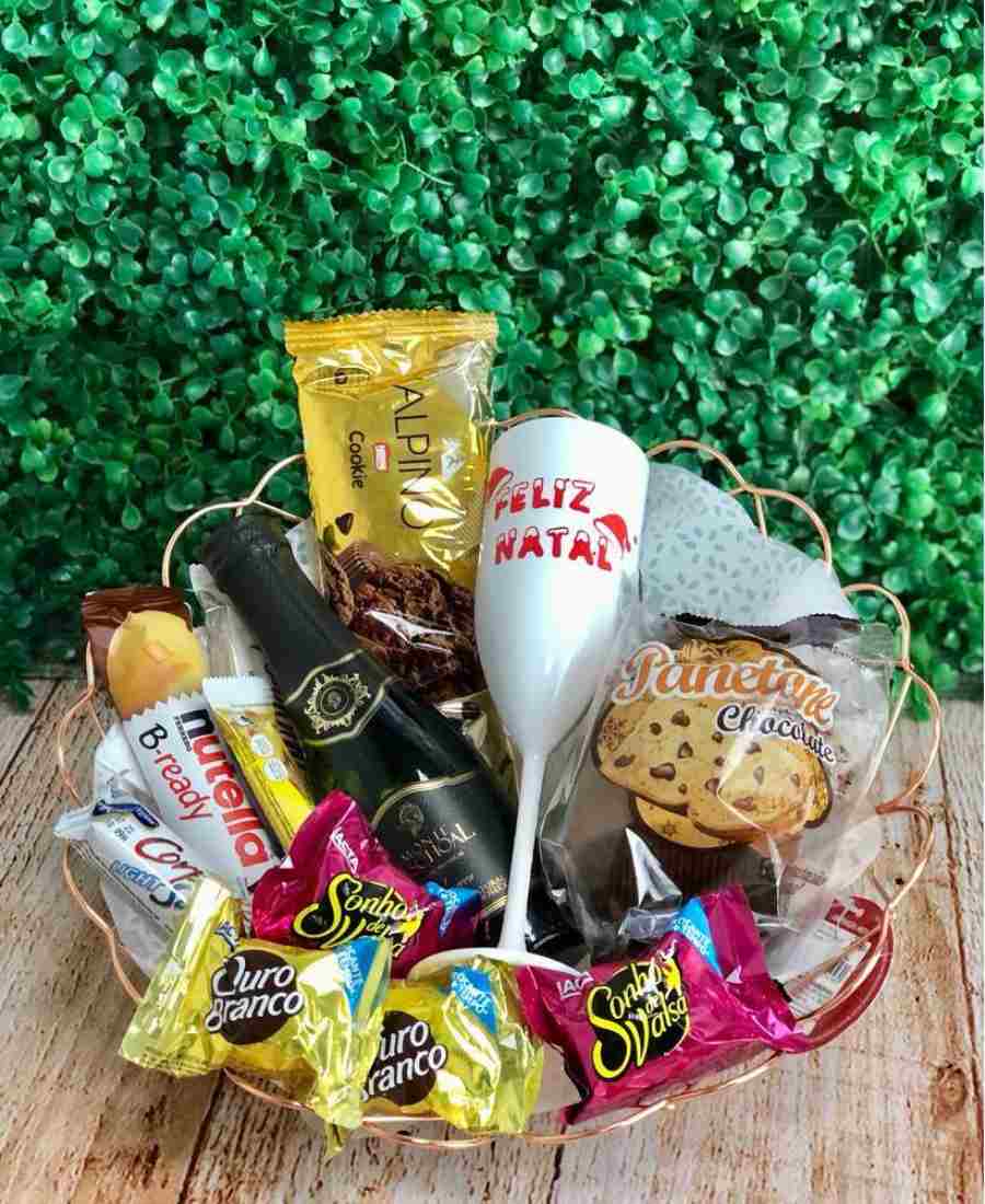 Cesta de doces para o Natal recheada com chocolates, bebida e taça.