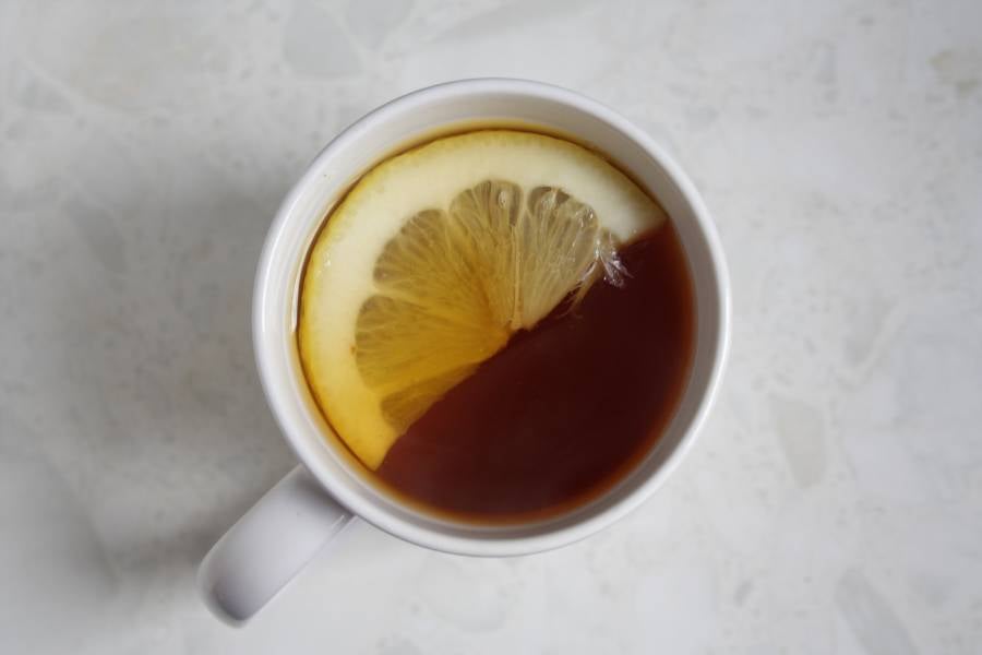 Chá de casca de limão com uma rodela da fruta na xícara.