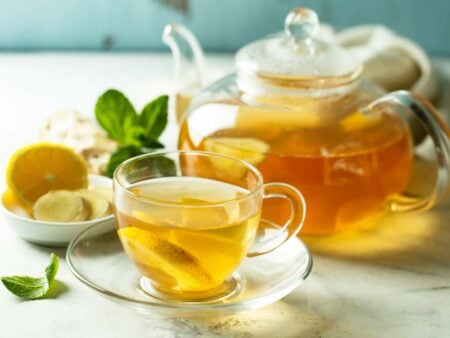 Bule e xícara com chá de casca de limão.
