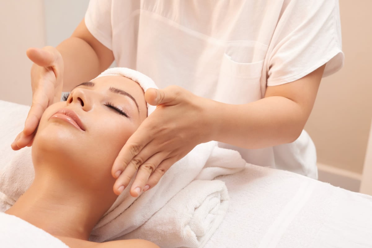 mulher fazendo massagem no rosto