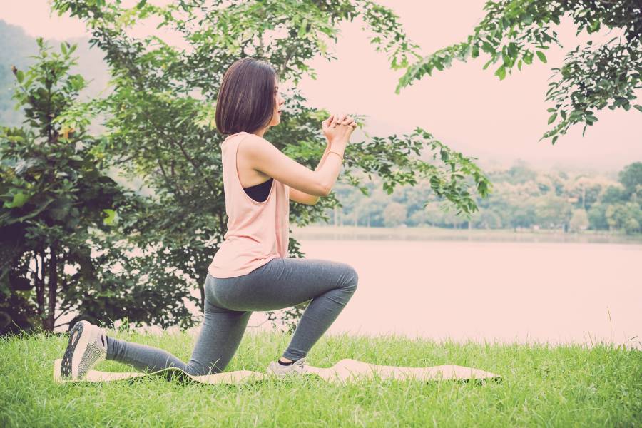Mulher fazendo yoga ao ar livre.