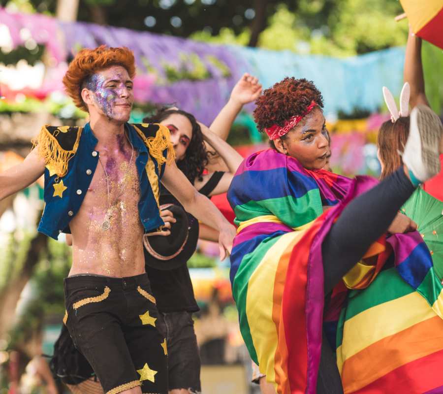 Foto de jovens fantasiados para o Carnaval, com maquiagem e bandeira LGBTQIA+.