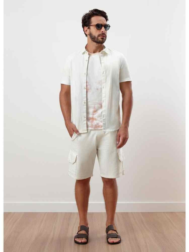 Ideia de look masculino para réveillon: camiseta + camisa de botões + bermuda nas cores branco.
