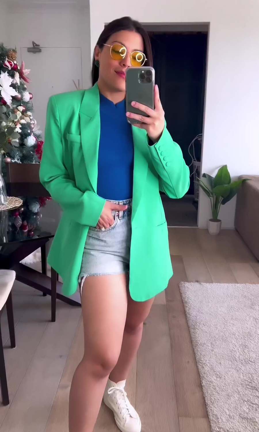 Look verde e azul: body azul + short jeans + blazer verde + óculos de sol + tênis branco.