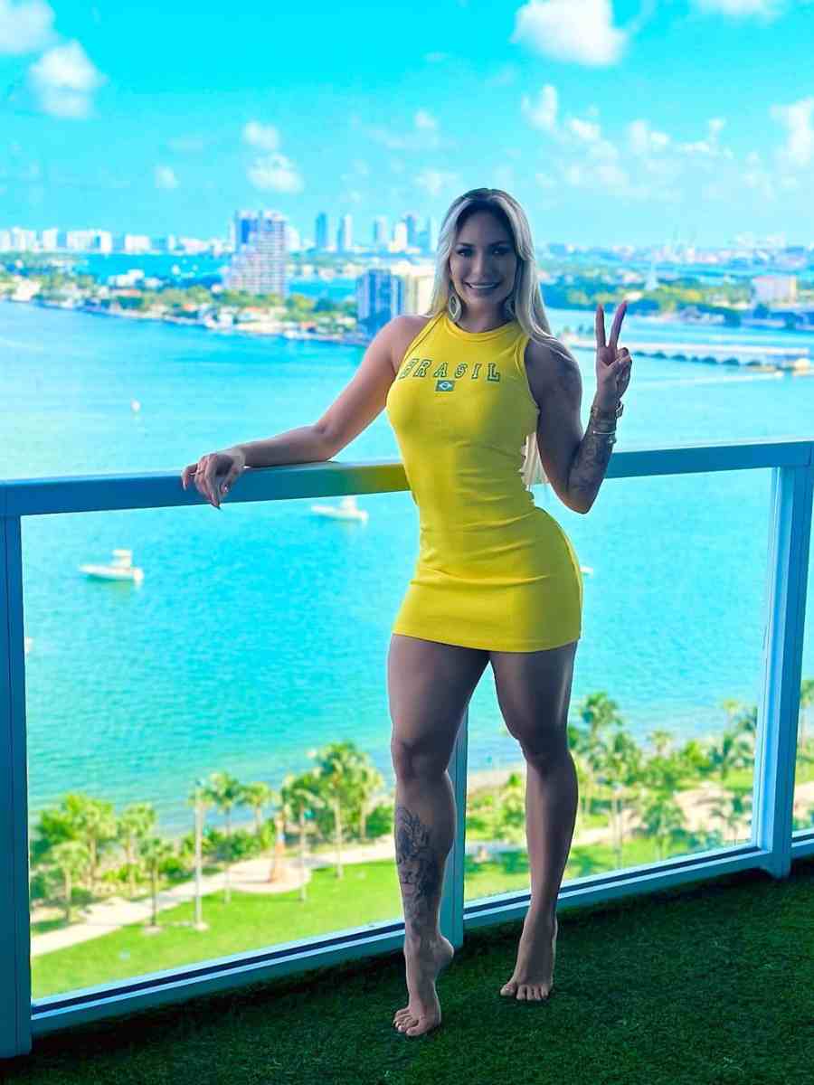Foto de mulher em prédio de frente para o mar, usando vestido amarelo do Brasil.