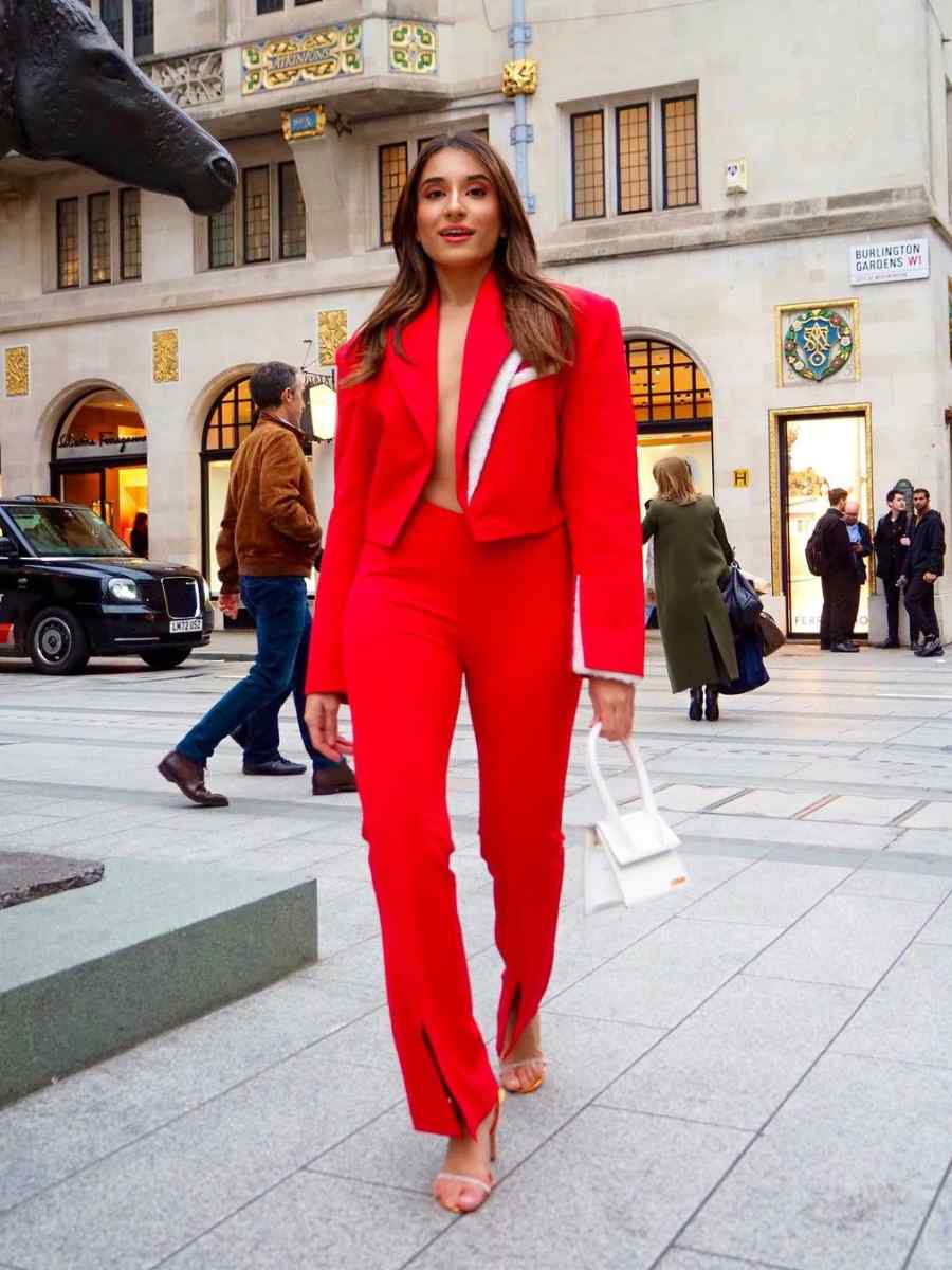 Mulher usando look all red composto por blazer e calça.