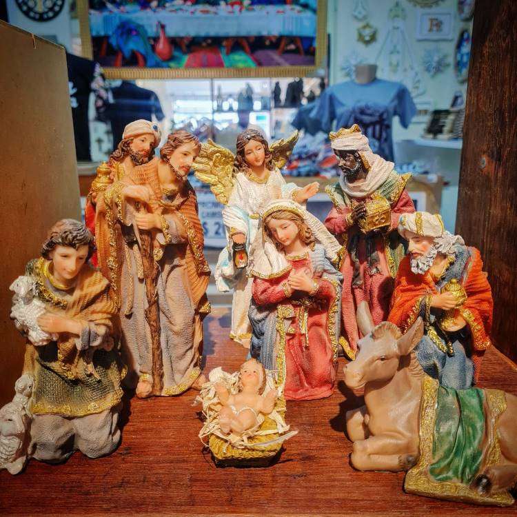 Presépio completo de porcelana com os Três Reis Magos, José, Maria, Jesus, anjos e um burro.