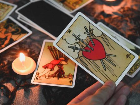 Foto de cartar de tarô sobre mesa com vela.