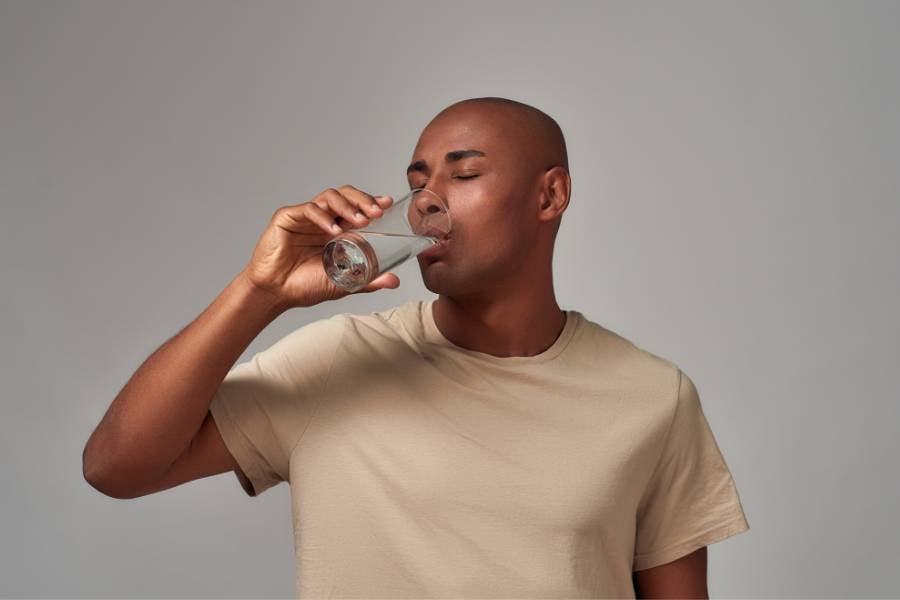 Homem tomando copo de água.