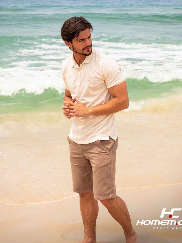 Ideia de look masculino para réveillon: camisa polo off white + bermuda jeans bege.
