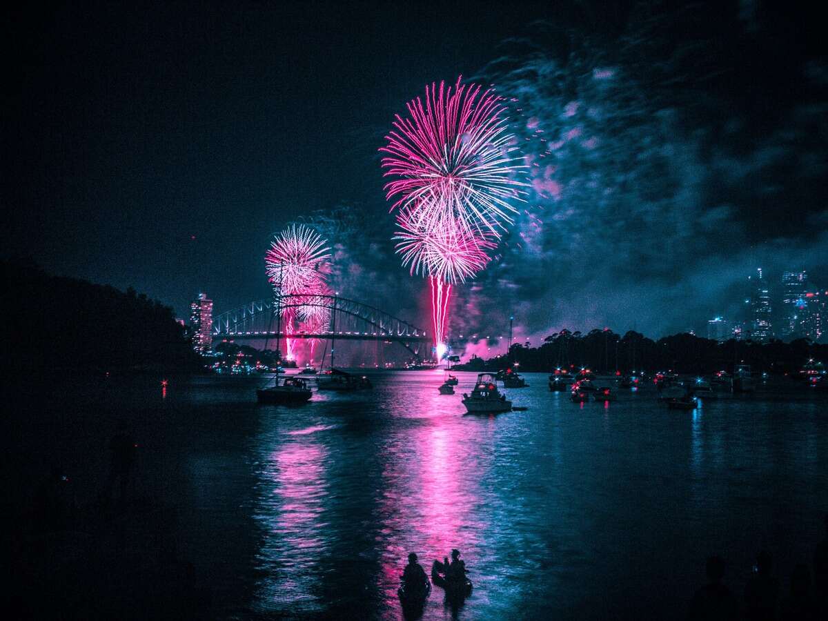 fogos de artifício como tradição ou simpatia de ano novo perto de um lago com uma ponte